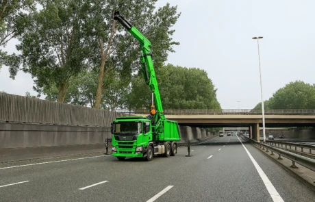 Élagage sur autoroute avec grue verte